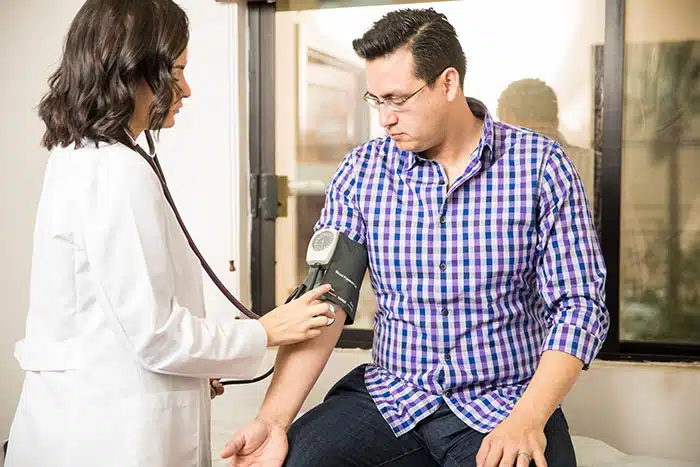 Young female doctor using a sphygmomanometer to measure a patient's blood pressure